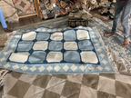 Blue and white checkered rug on a patterned floor 