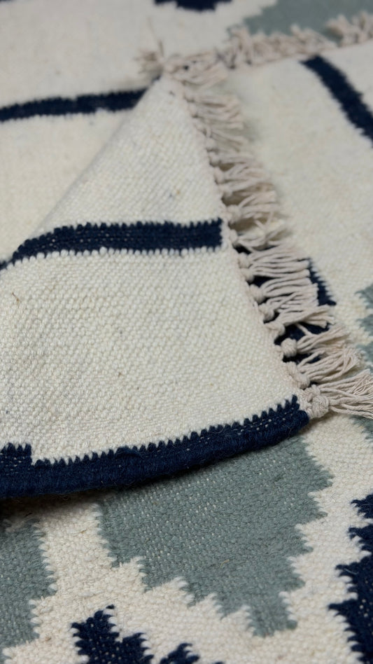 Close-up of a patterned rug with blue and white colors.