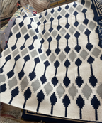 Patterned Rug with black and gray design on a surface