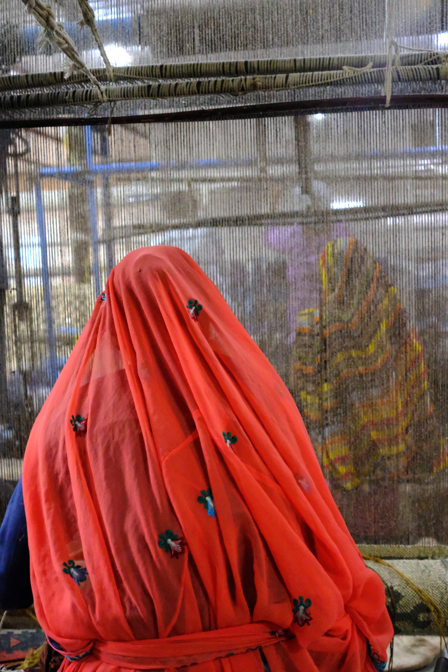 Ima female artisan weaving a rug with hand