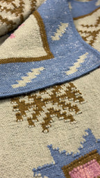 Close-up of the rug with pattern in blue, brown, and grey.