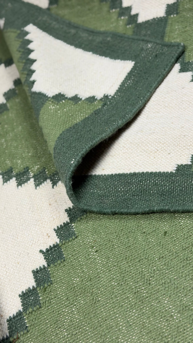 Close-up of a green and white patterned rug