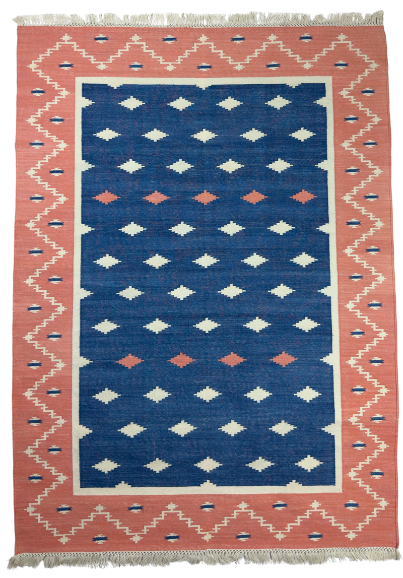 Rug with geometric pattern featuring blue, pink, and white colors