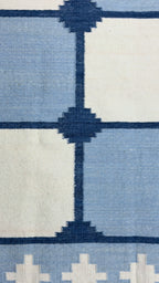 Close-up of a patterned rug with blue and white design