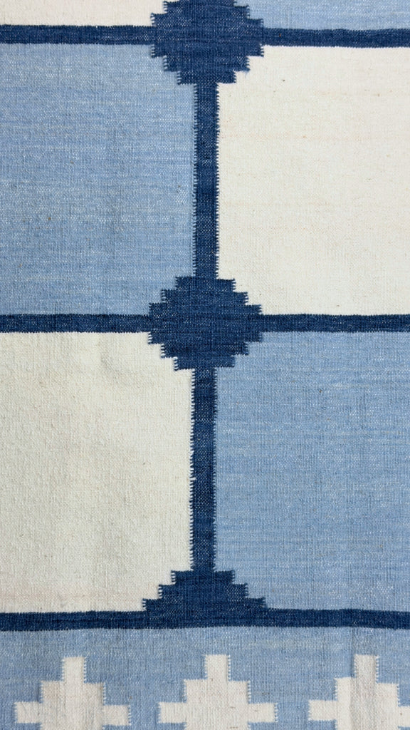 Close-up of a patterned rug with blue and white design