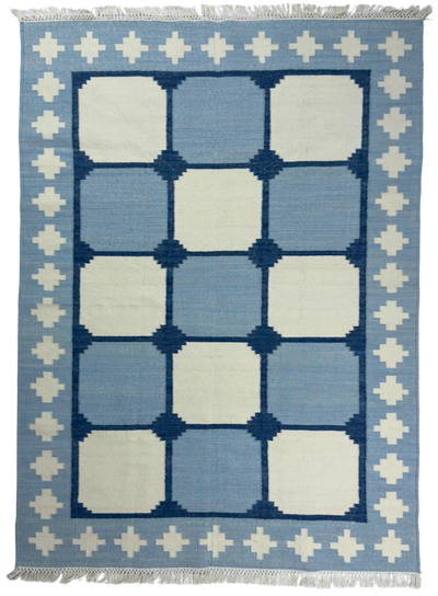 Blue and white geometric patterned rug with decorative border