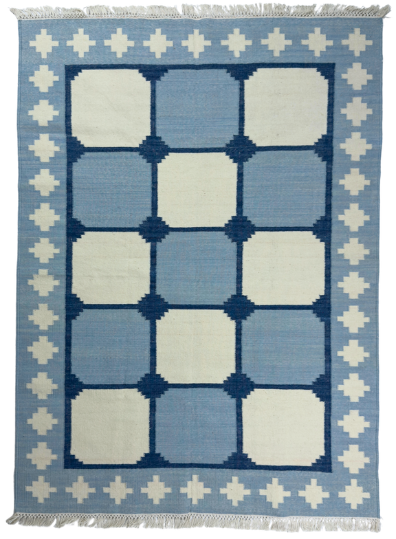 Blue and white geometric patterned rug with decorative border