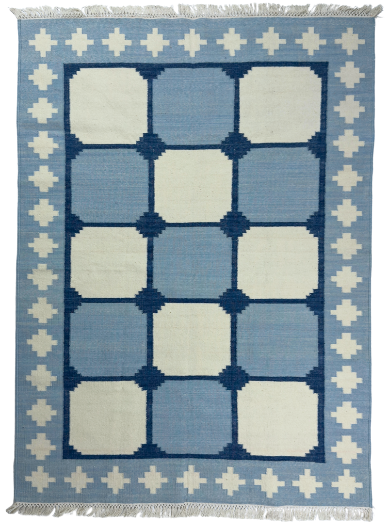 Blue and white geometric patterned rug with decorative border