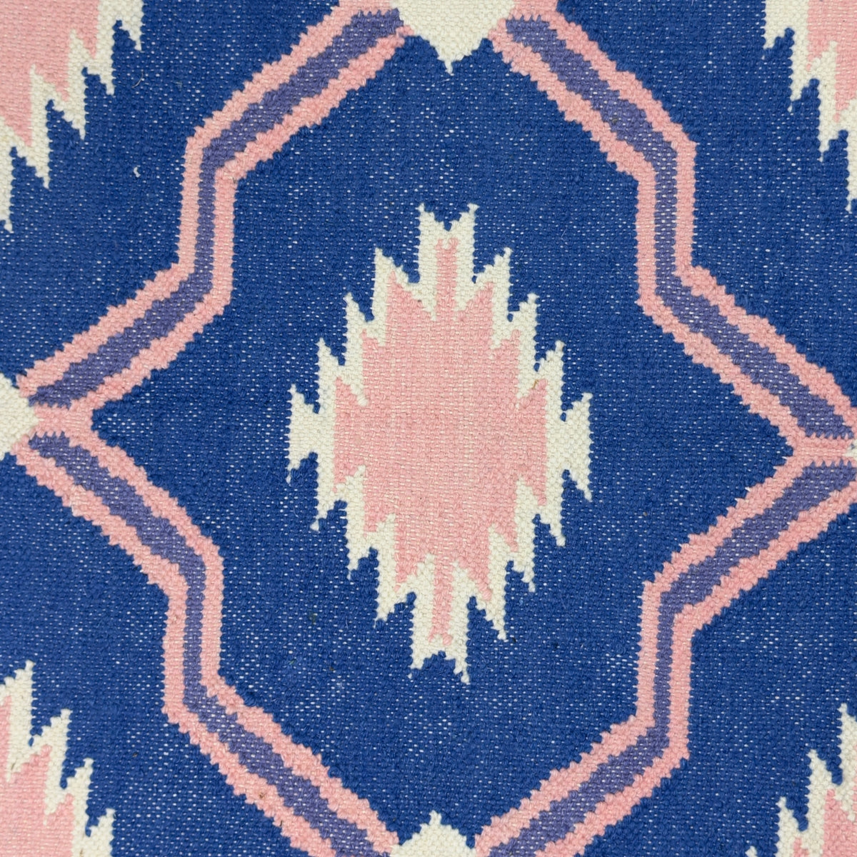 Close-up of a rug with a geometric pattern on a blue background