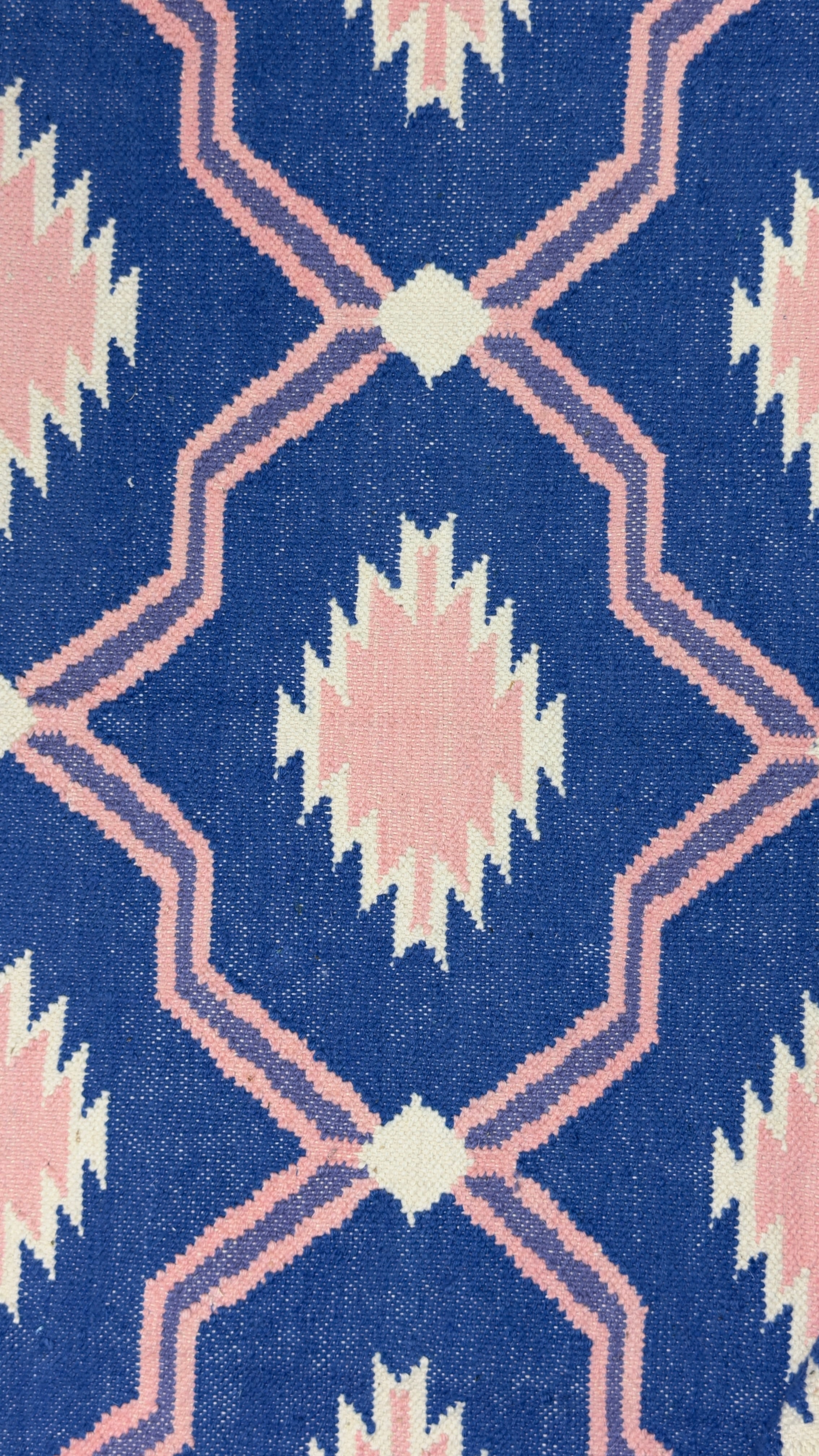 Close-up of a rug with a geometric pattern on a blue background