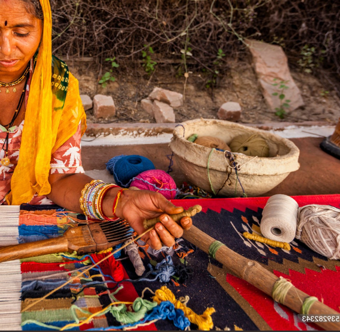 Woman weaving with colorful yarn in a natural setting